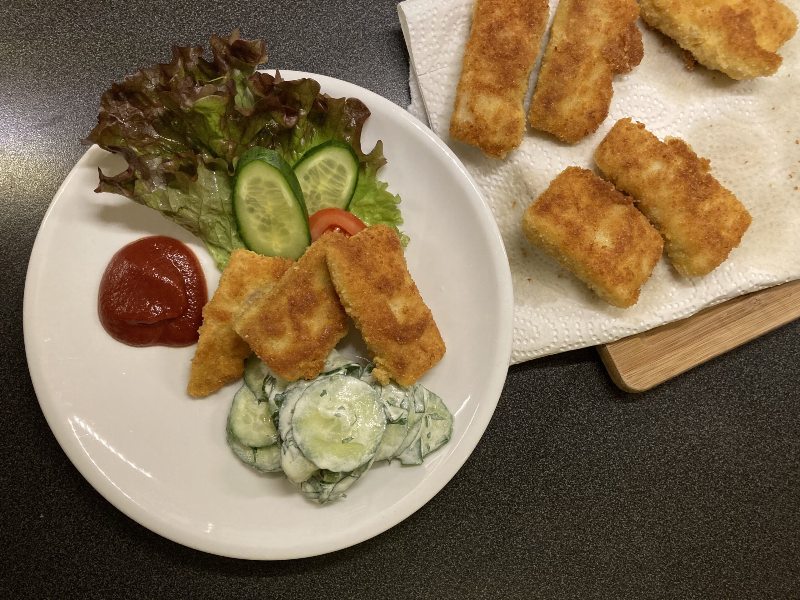 Selbstgemachte Fischstäbchen mit cremigem Gurkensalat